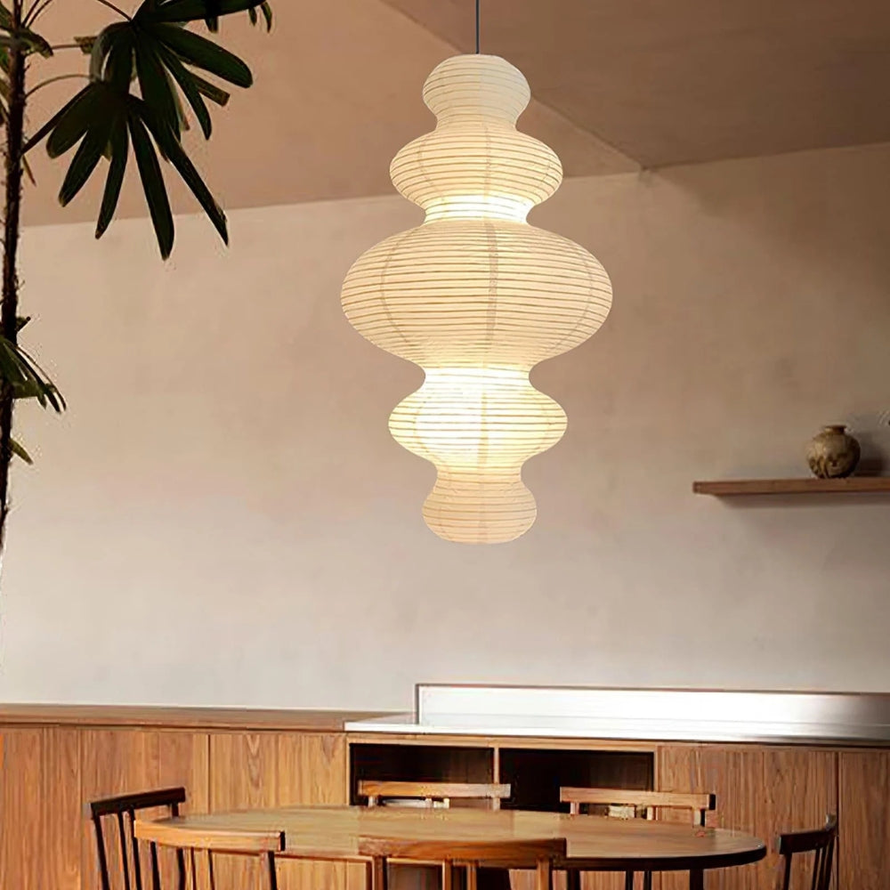 Akari Juni Paper Pendant Light in dining room, hourglass shade centered above the table diffusing an even glare-free wash across place settings
