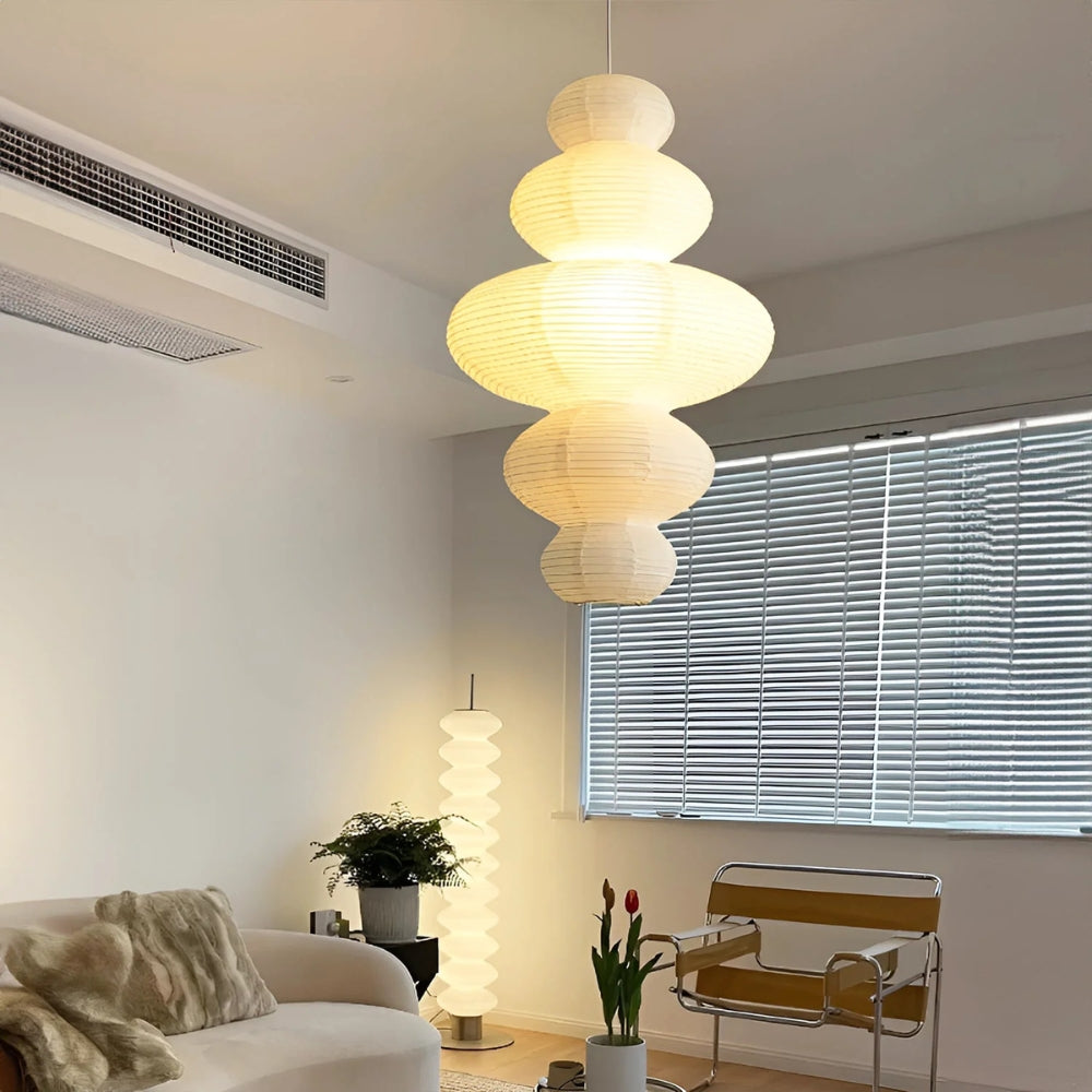 Akari Juni Paper Pendant Light in living room, pleated rice paper shade spreading soft ambient glow across the seating area as a centerpiece