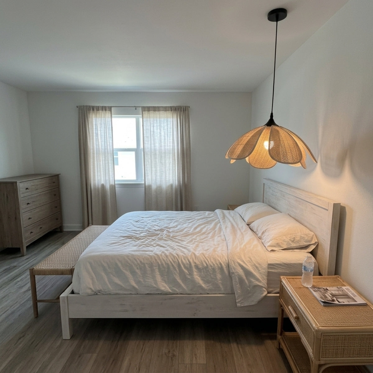 Bloom Wabi Sabi Rattan Pendant Light in bedroom, small flower-petal shade beside the bed clearing pillows and headboard while replacing a nightstand lamp