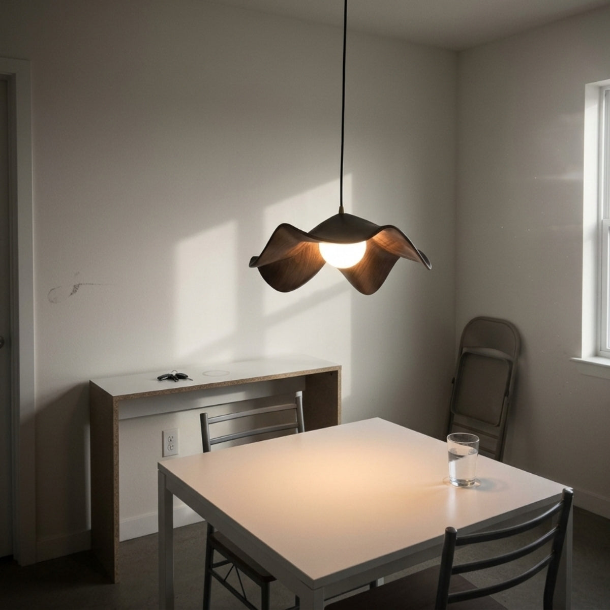 Casia Lotus Wabi Sabi Wood Pendant Light above dining table, wave shade channeling light straight down without glare across place settings