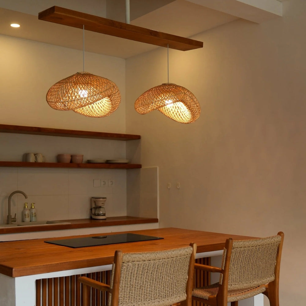 Generis Wabi Sabi Wave Rattan Pendant Light over kitchen island, three 15.7-inch shades clustered, brighter bulbs cutting shadows across the work surface below