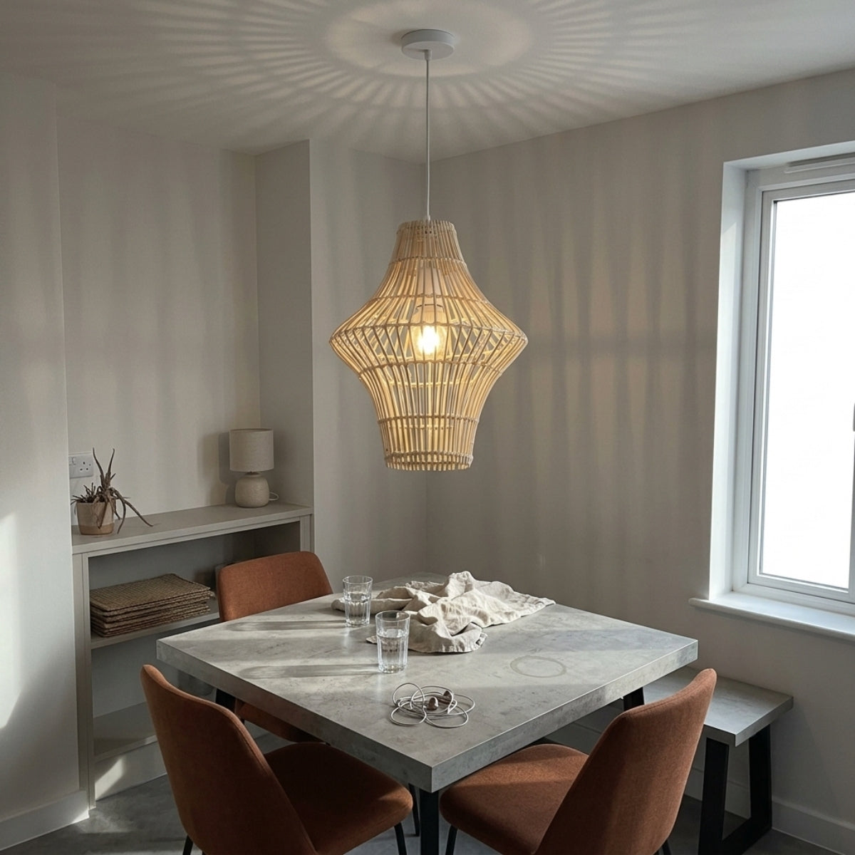 Geometric Rattan Pendant Light in dining room, hourglass shade over the table, open weave lighting the tabletop evenly without glare reaching diners eyes
