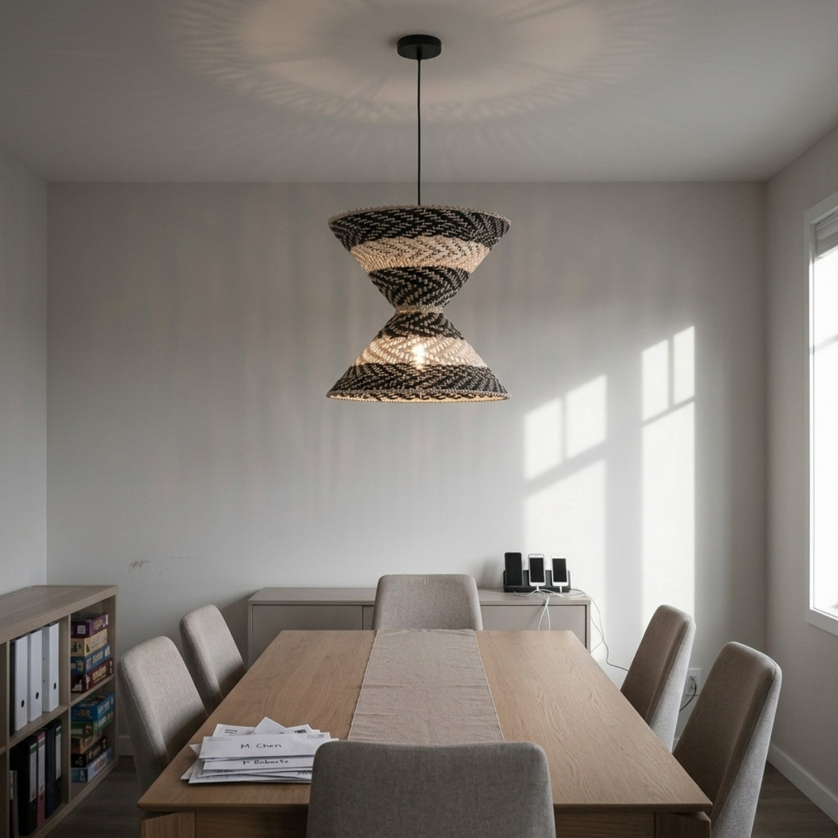 Hourstria Rattan Black Wicker Pendant Light in dining room, hourglass shade over the table, black and natural bands casting warm glow across place settings