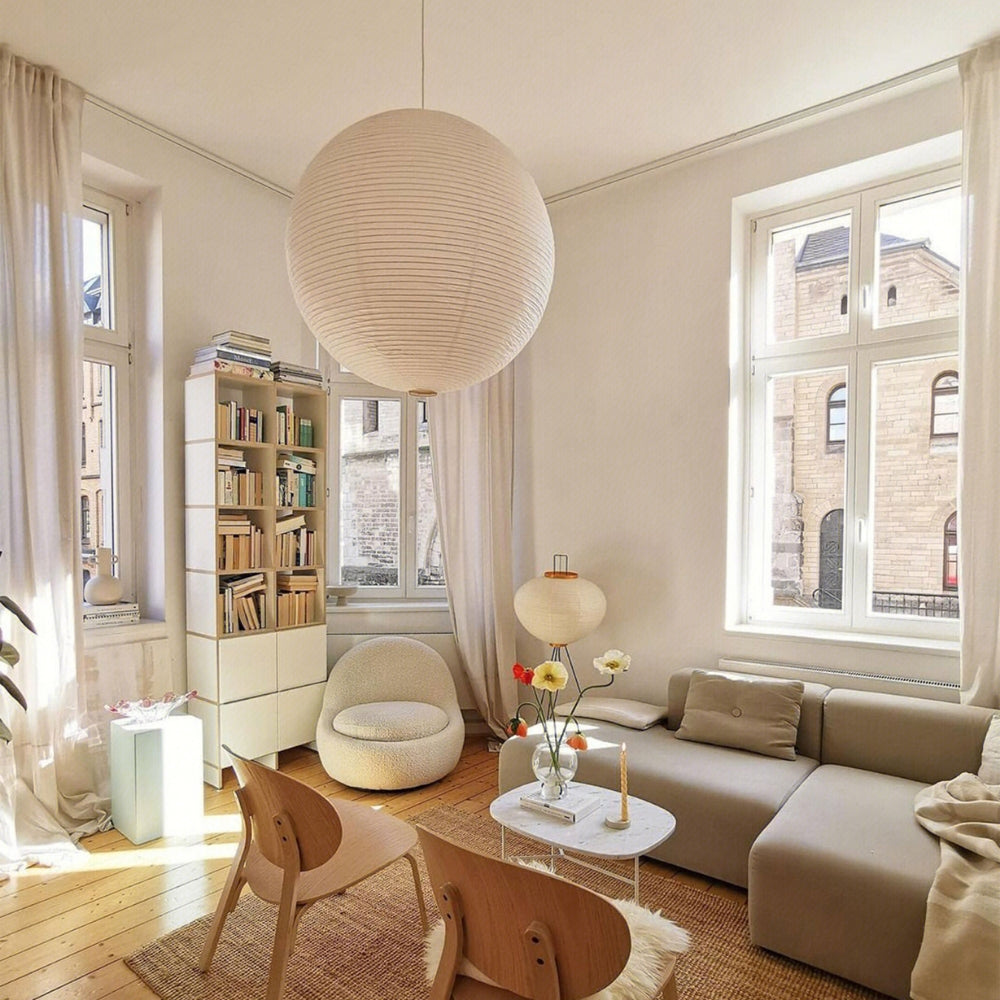 Japanese Wabi Sabi Rice Paper Ball Pendant Light in living room, 23.6-inch globe centered over the coffee table glowing evenly toward the sofa as a centerpiece
