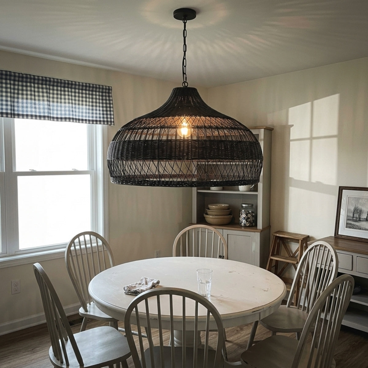 Moijabana Black Woven Wicker Rattan Dome Pendant above dining table, open weave dome covering the table while softening glare from the bulb