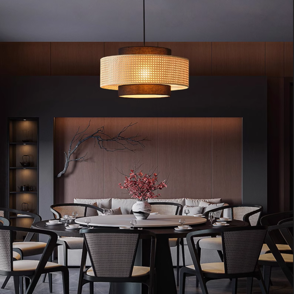Nivara Black and Rattan Drum Pendant above dining table, 23.6-inch drum covering the table with soft glow instead of glare at eye level