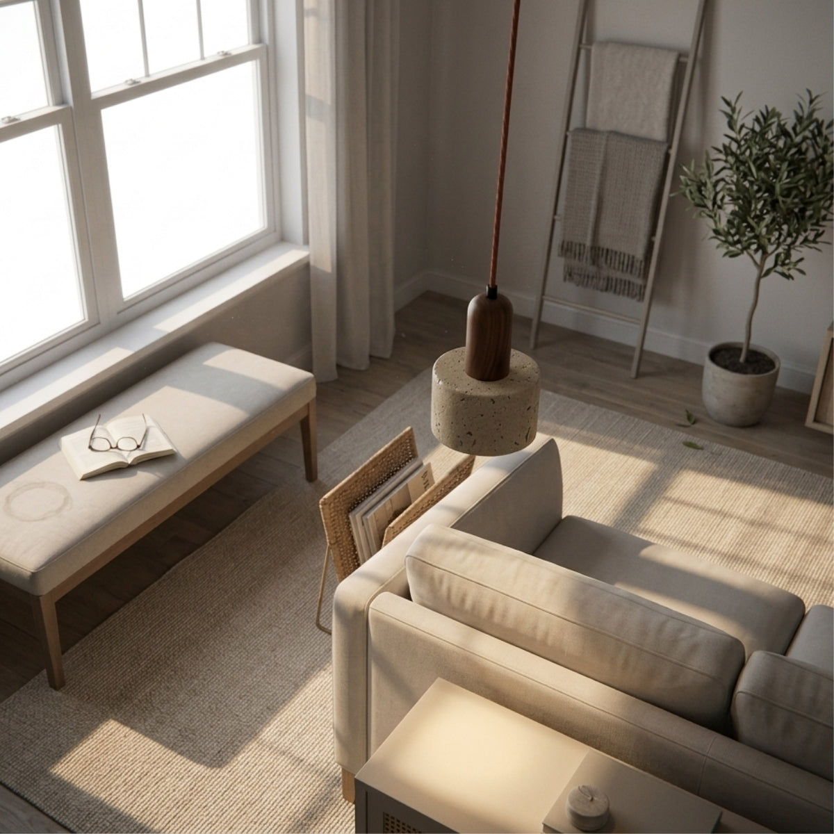 Ora Wabi Sabi Cylinder Pendant in living room, its compact travertine shade over a side table reading as an accent glow beside the sofa