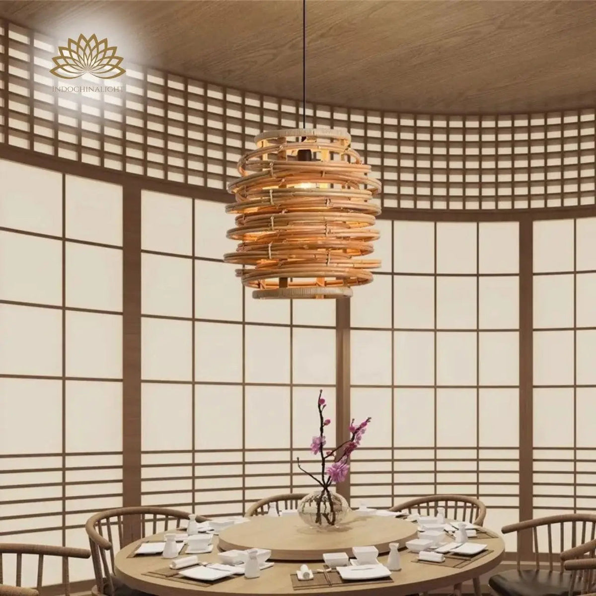 Oriana Grass Bamboo Pendant in dining room, the coiled bands sitting above eye level over a six-seat table centered above the tabletop