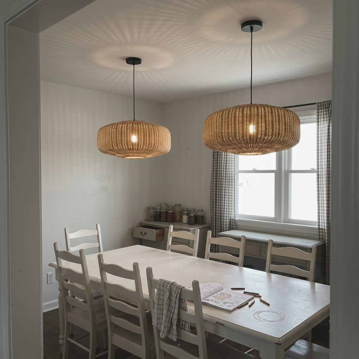 Sia Wicker Drum Pendant Light in dining room, open-weave drum spanning the table end to end while keeping glare off the surface below