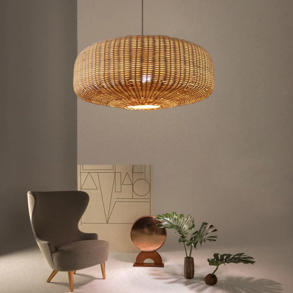 Sia rattan pendant lamp hanging over a gray armchair in a room