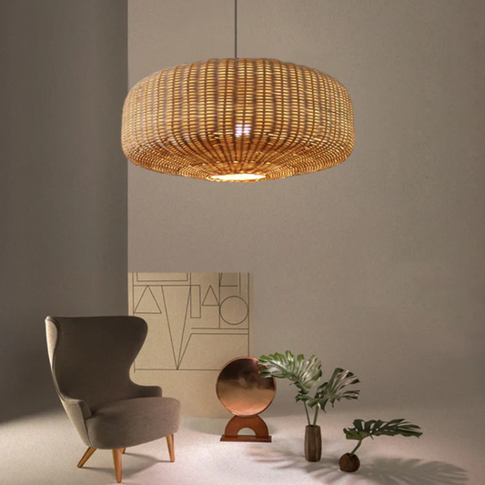 Sia rattan pendant lamp hanging over a gray armchair in a room