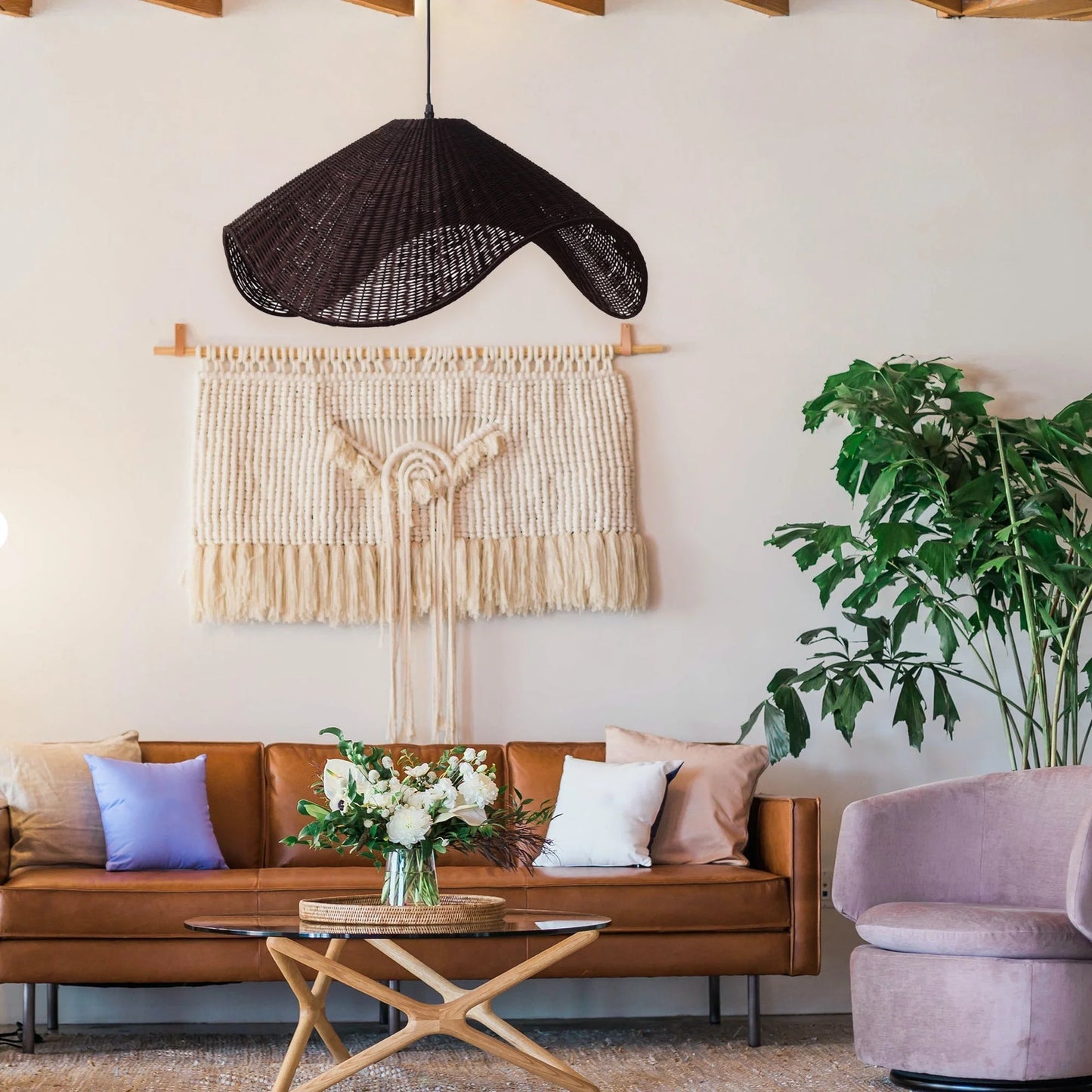 Adaya Black Rattan Pendant Light hanging in a Rustic Living Room