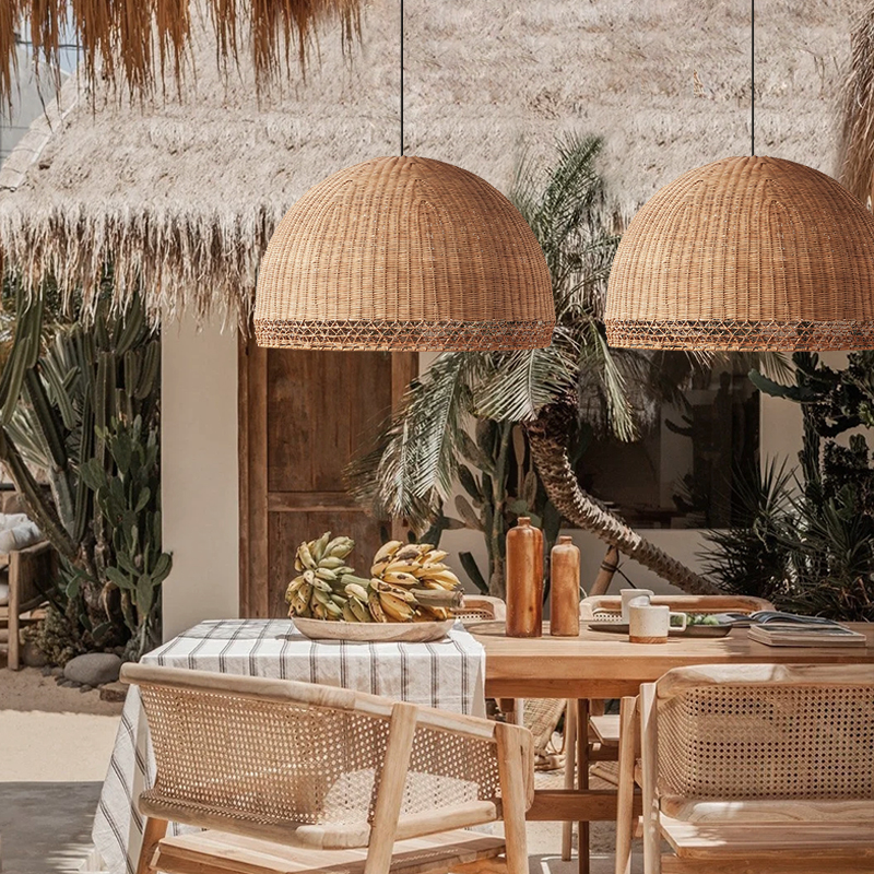 Augusta Dome Wicker Rattan Pendant Lamps hanging over outdoor dining table