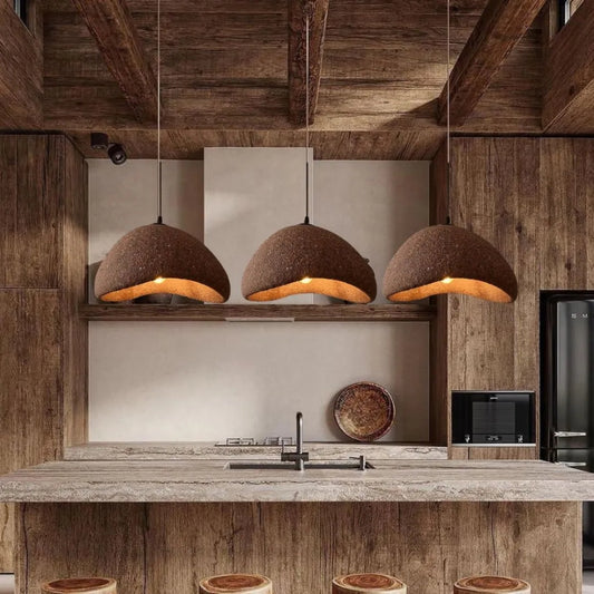 Cluster of three small stone pendant light fixtures above the kitchen island