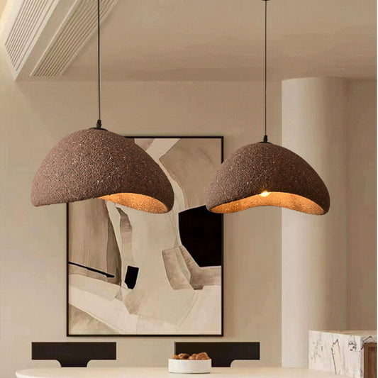 Handcrafted wabi sabi pendant light stone fixture hanging over wooden dining table