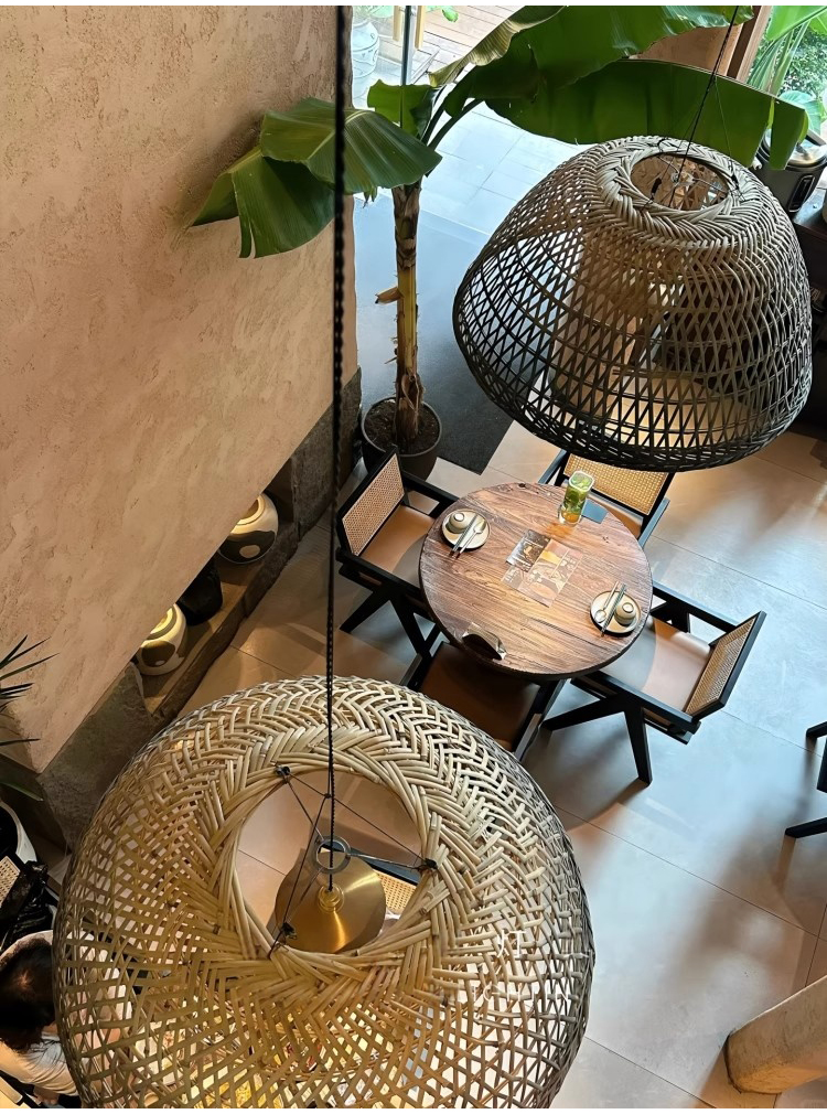Neroweave Extra Large Black Dome Rattan Pendant Light hangs over Coffee Table